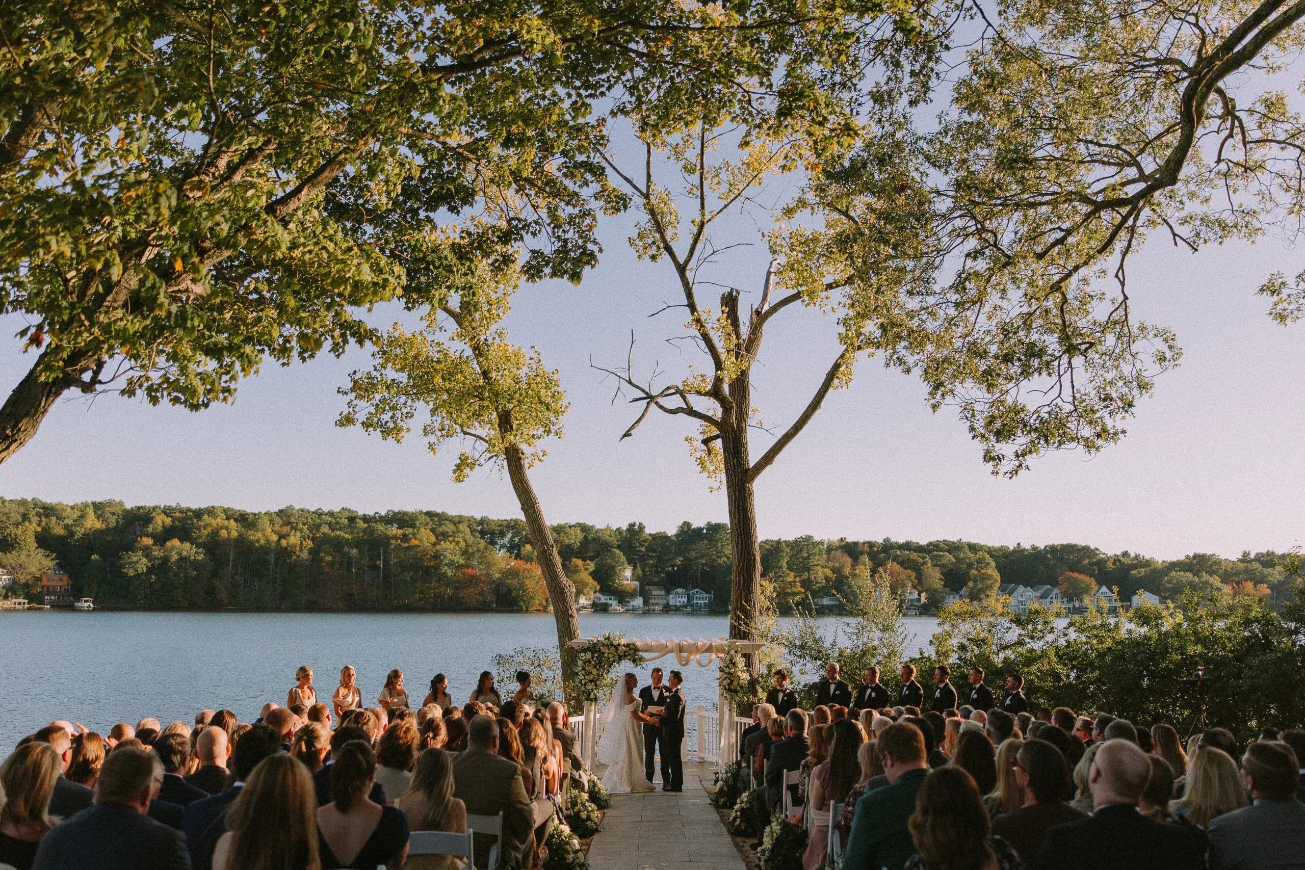 Lakeside wedding ceremony framed by trees at the water's edge, Lake Pearl Wrentham